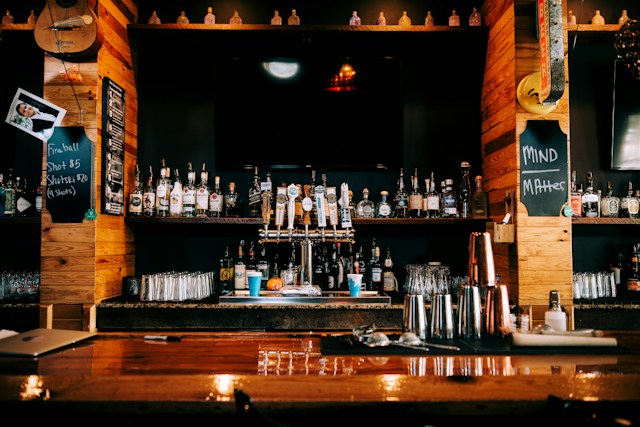 Bar counter with shelves of bottles