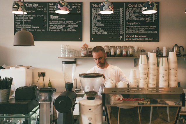 Barista working behind a coffee shop counter